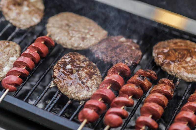 Hamburger e spiedini di salsicce alla griglia su barbecue