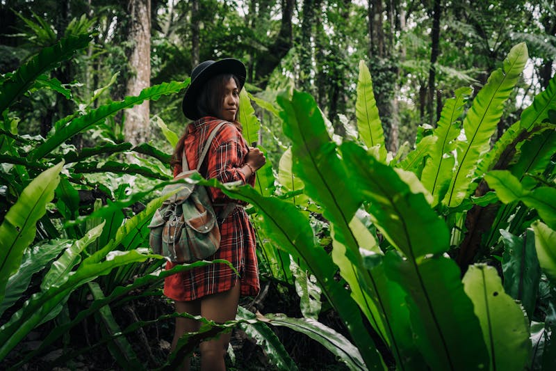 Giovane viaggiatrice con zaino in un paesaggio naturale tropicale